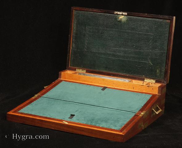 -Brass boundsolid mahogany triple opening writing box   in the military  style with countersunk carrying handles  by Austen of Dublin: the fitted compartmentalized  interior has a document wallet,   secret drawers,  a replacement velvet writing surface , and working lock with key, Circa 1830 Enlarge Picture